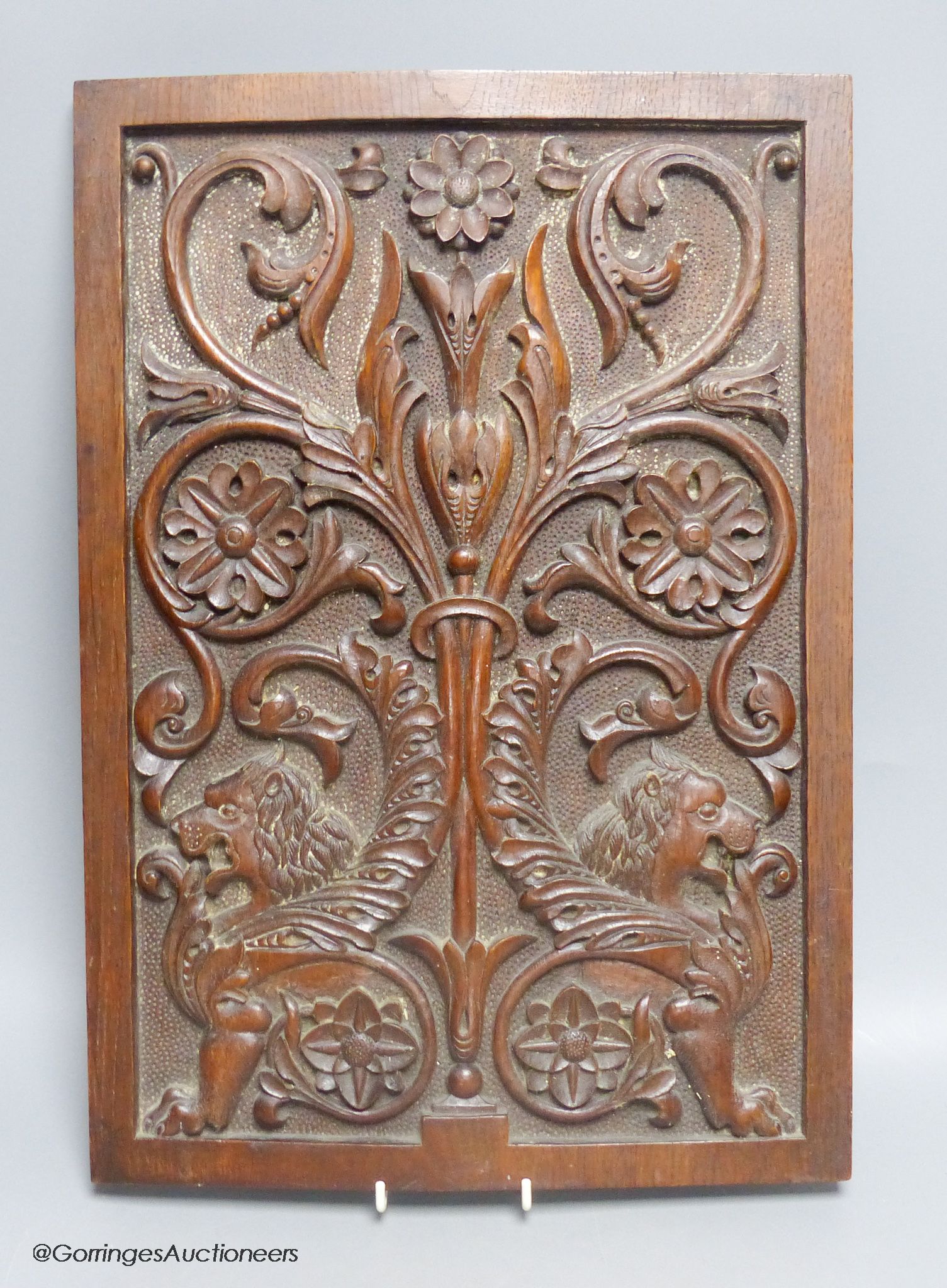 A carved oak panel depicting lions and floral pattern, 44.5 x 31cm